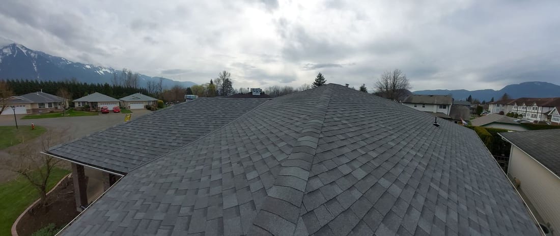 Completed asphalt shingle roof with a mountain view