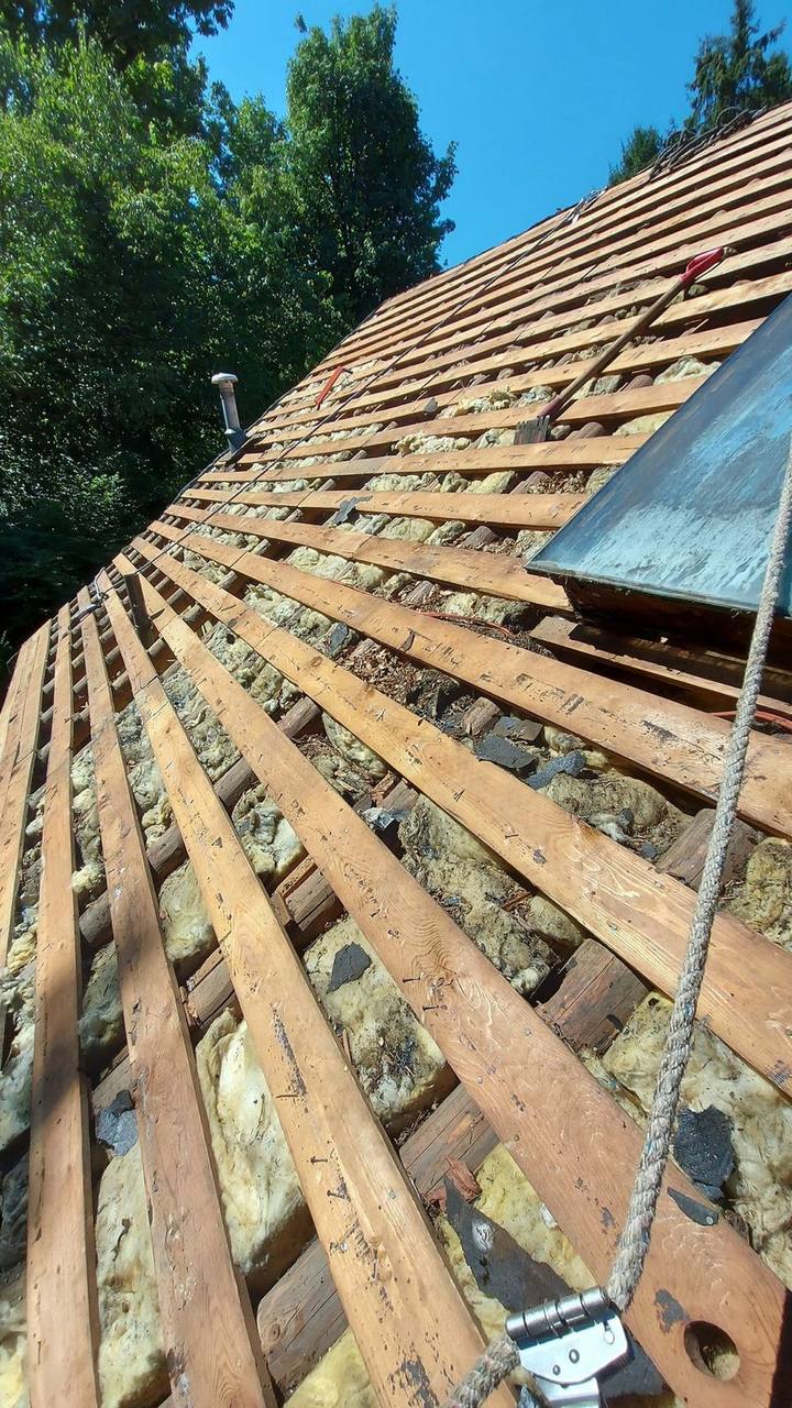 Cedar shake roof stripped to skip sheathing during emergency tear-off in the Fraser Valley, a vulnerable state requiring immediate tarping protection by Fraser Roofing