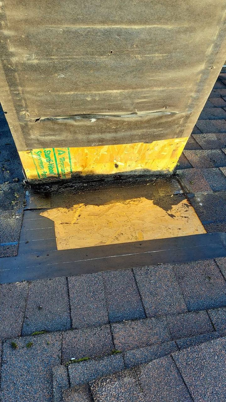 Chimney flashing repair in progress showing yellow waterproof membrane and tar sealant on Fraser Valley roof by Fraser Roofing
