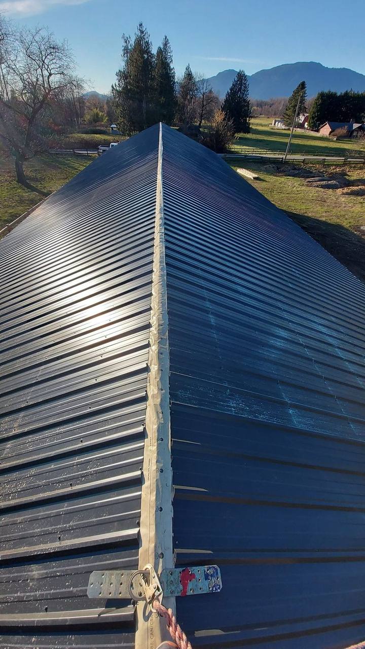 Finished dark metal roof along the ridge, roof anchor set