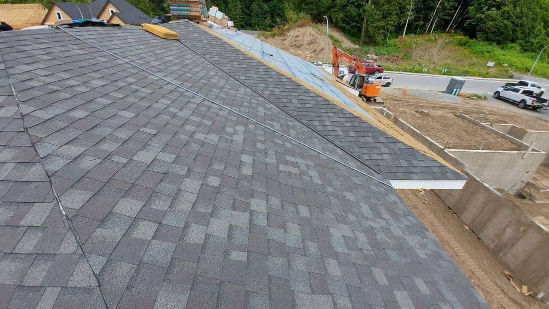 New construction roof shingling with charcoal architectural asphalt shingles on a residential home in the Fraser Valley BC by Fraser Roofing