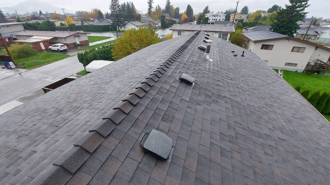 Completed asphalt shingle roof installation with ridge cap and ventilation in a Fraser Valley BC neighborhood by Fraser Roofing, a clean professional finish that adds real value at resale
