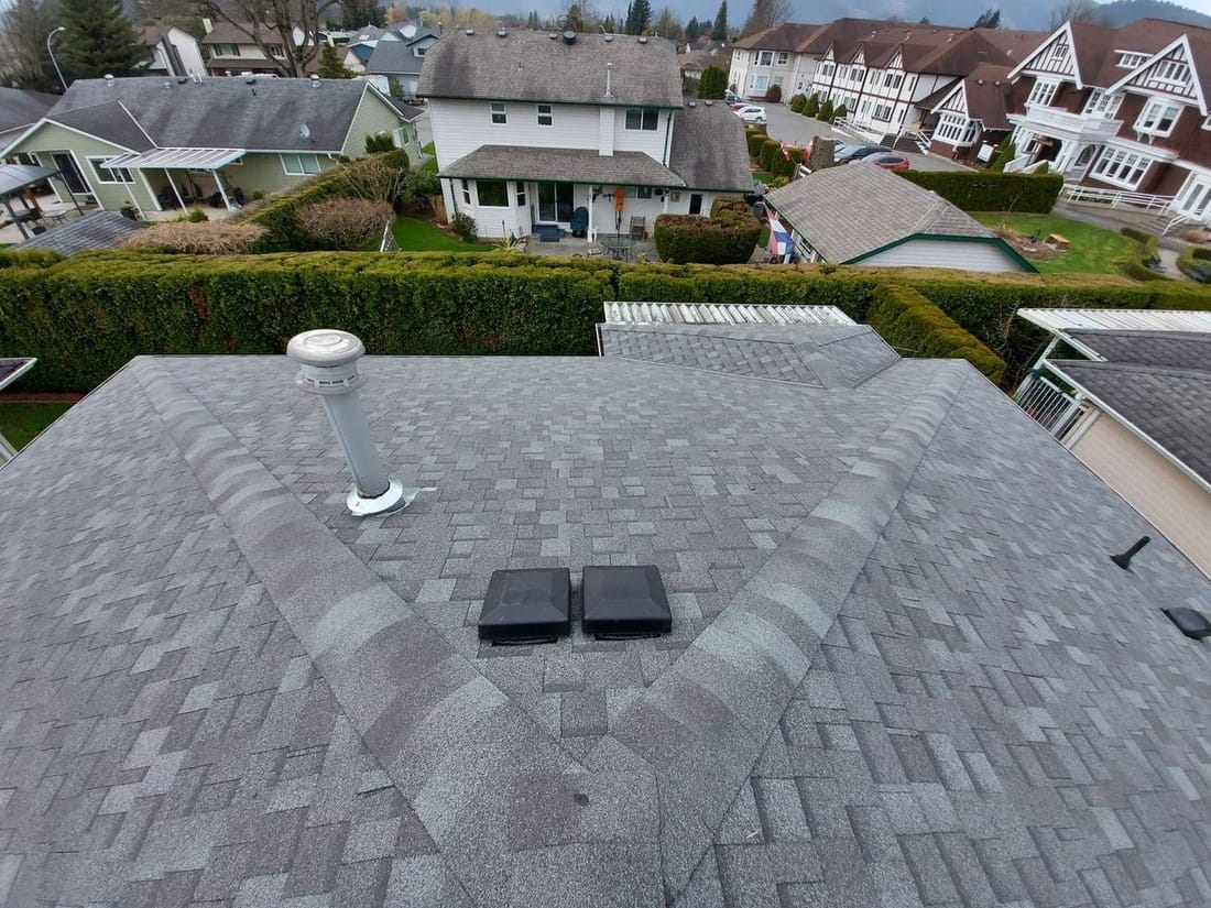Completed hip roof with grey architectural asphalt shingles and roof vents installed by Fraser Roofing in the Fraser Valley, professional quality results Mission homeowners can expect