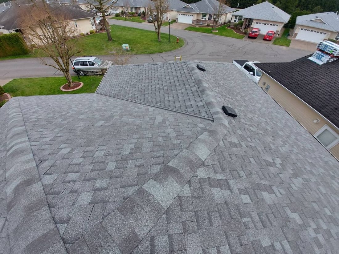 Completed grey architectural shingle roof installation on a residential home in the Fraser Valley viewed from above showing clean ridge lines and professional workmanship by Fraser Roofing