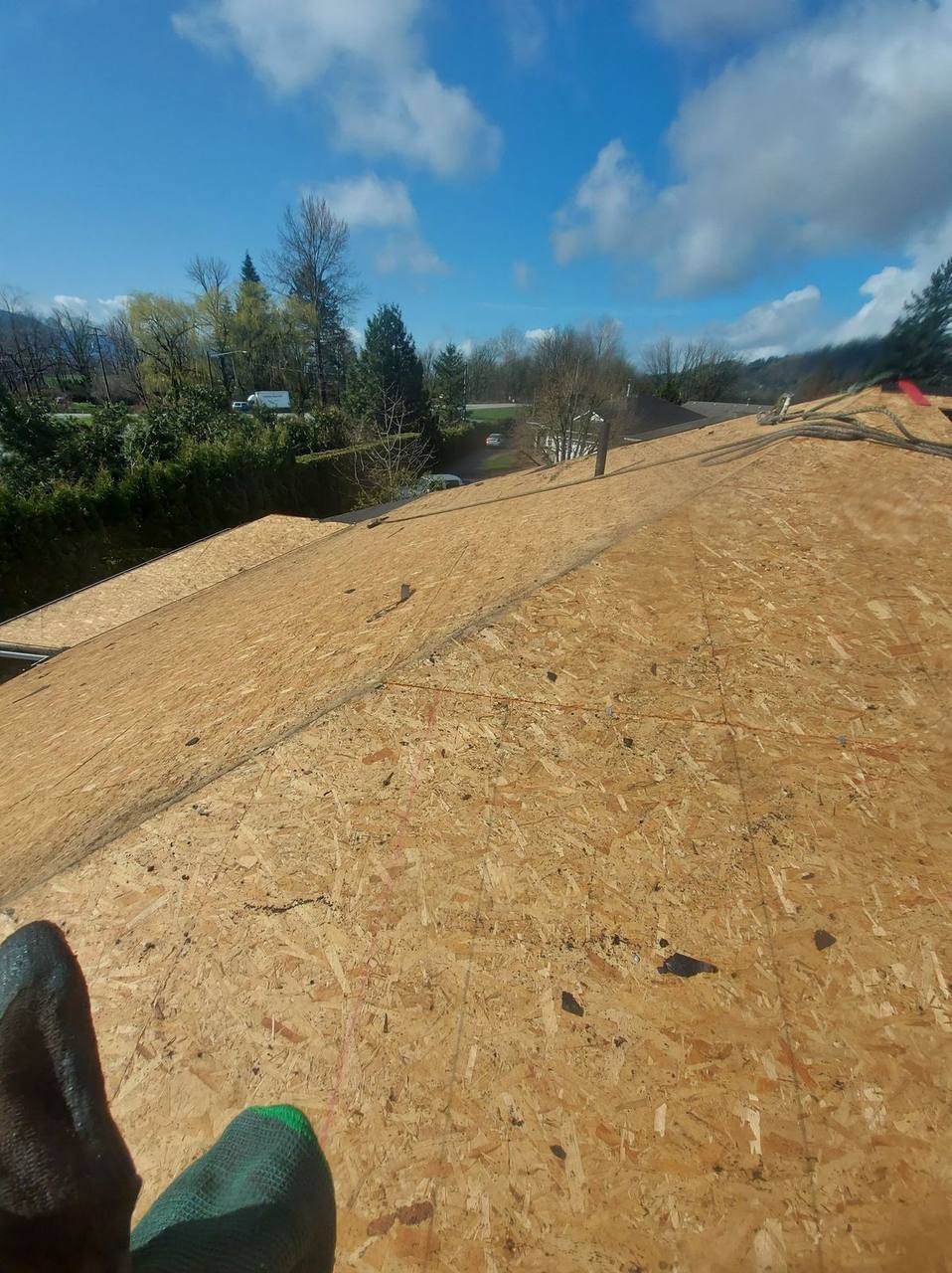 Roofer POV on new OSB sheathing deck during Fraser Valley roof replacement by Fraser Roofing crew