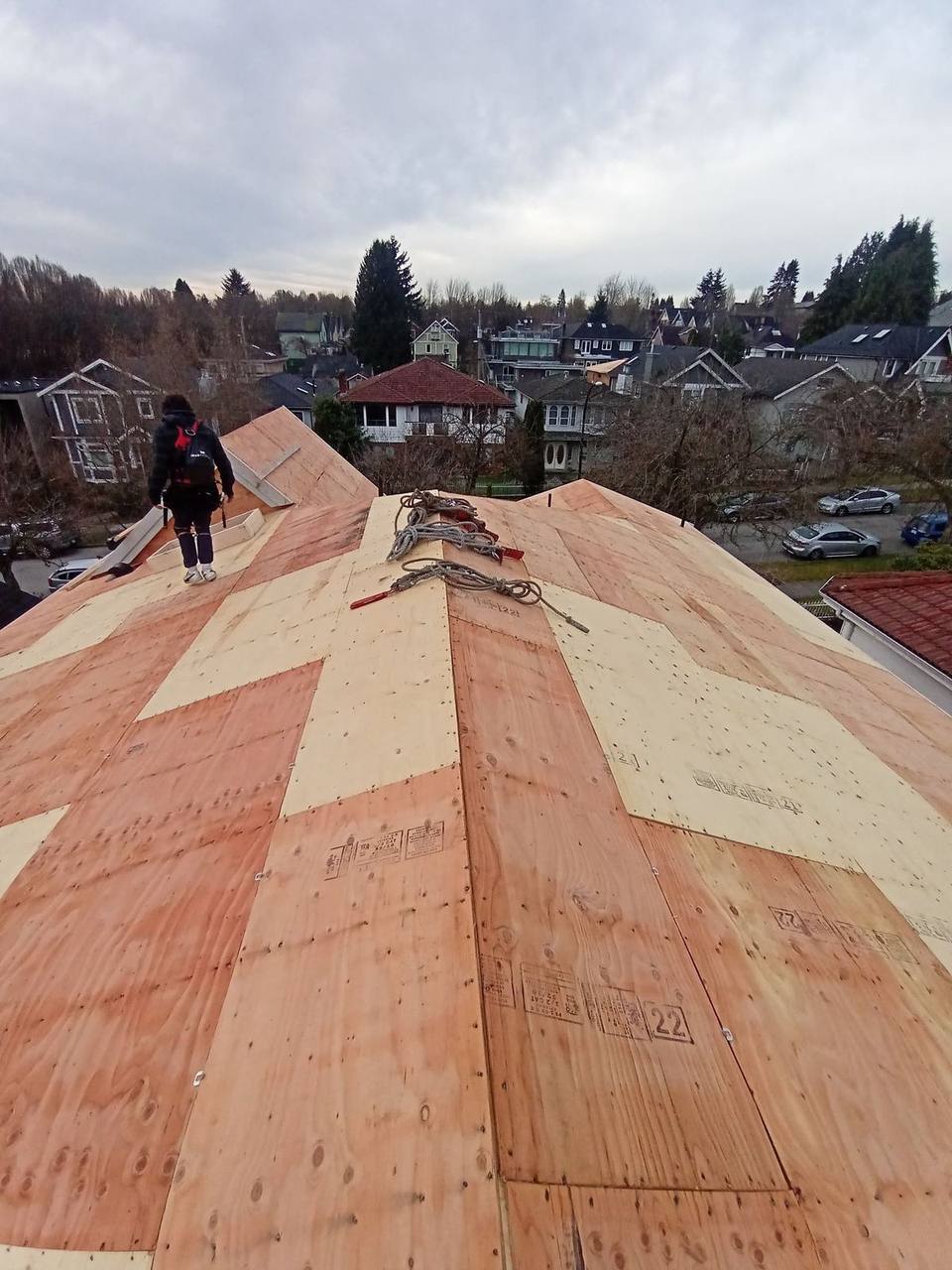 Fraser Roofing crew member on freshly sheathed plywood roof deck during full residential re-roof in Fraser Valley