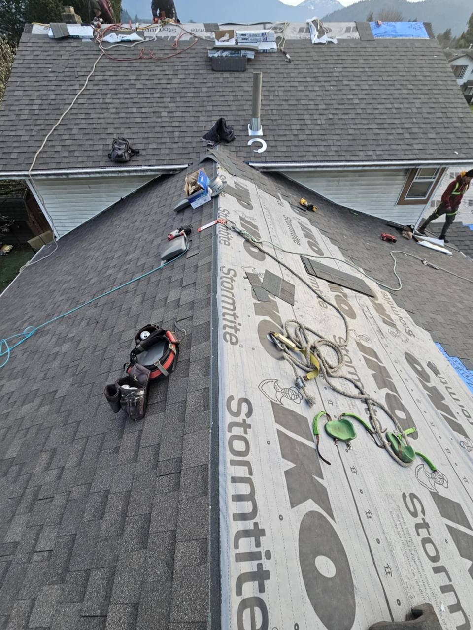 Near-complete shingled roof in Chilliwack BC showing final shingle courses being installed - shingle type comparison