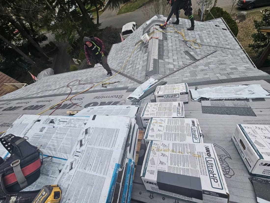 Fraser Roofing crew mid-job on a shingled residential roof in Chilliwack with shingle bundles staged on the roof, showing the kind of dedicated work we bring to remote Yale properties