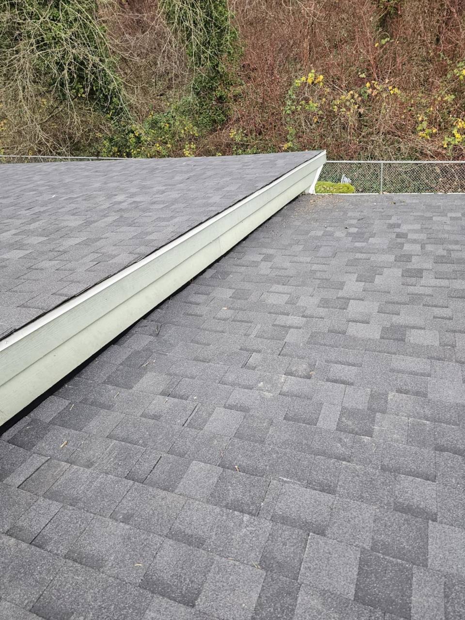 Metal counter flashing at shingle-to-wall junction on completed Chilliwack residential roof by Fraser Roofing