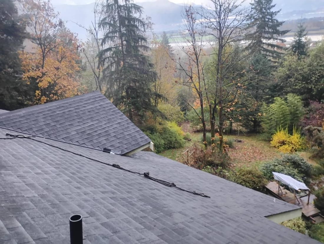 Completed shingled residential roof in Chilliwack by Fraser Roofing with a view of the Fraser River and valley below, representing the communities we serve including Yale