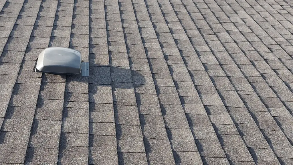 A long grey-brown asphalt shingle roof slope stretches into the distance with three low-profile roof vents along it. Fraser Roofing