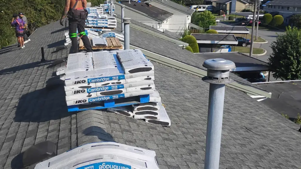 Bright sunny day on a ridge stacked with IKO Cambridge shingle bundles. Fraser Roofing