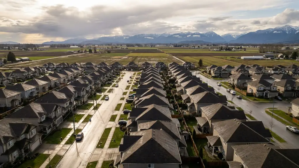 Aerial view of a Chilliwack neighbourhood after a storm, mountains on the horizon. Fraser Roofing
