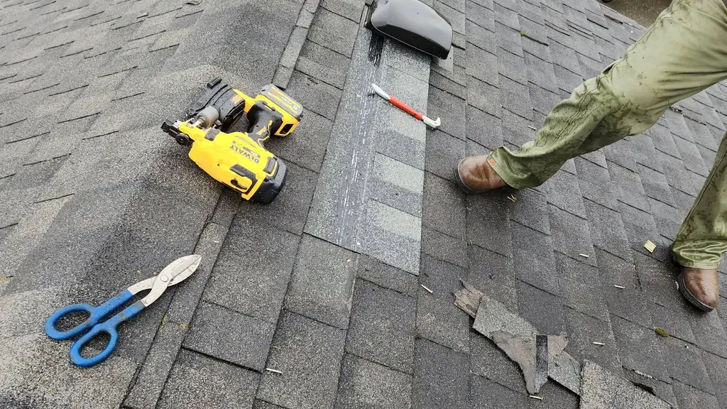 Roofer finishing a wind damage repair near the roof vents. Fraser Roofing