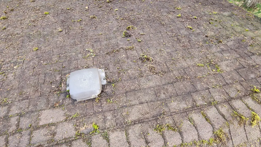 A dirt- and debris-covered low-slope asphalt shingle roof section is shown from above, with a plastic roof vent cap sitting in the middle. Fraser Roofing