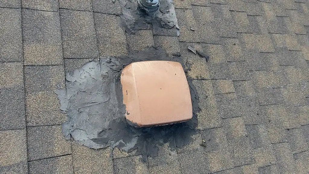 A close-up of two roof vents, a low-profile grey plastic vent and a tan/terracotta coloured vent. Fraser Roofing