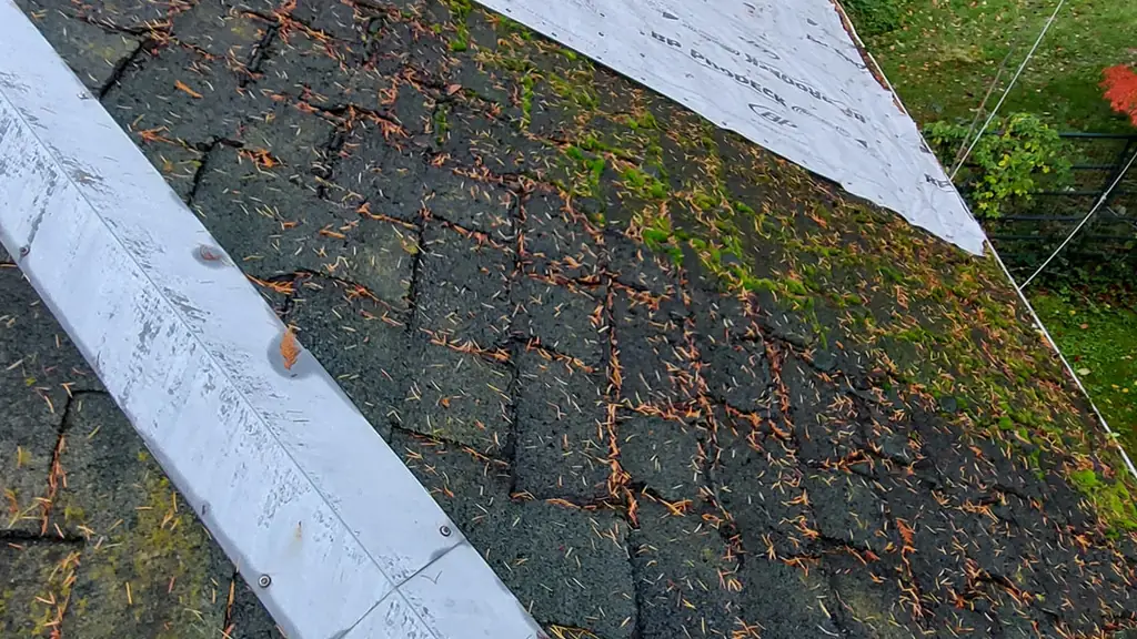 A strip of new white BP ProDeck ice-and-water-shield underlayment has been rolled out along a roof ridge. Fraser Roofing