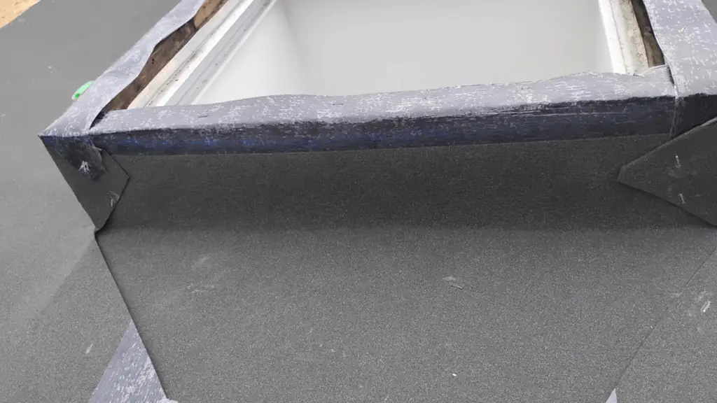 A skylight curb is being waterproofed with a black rubberized peel-and-stick membrane. Fraser Roofing
