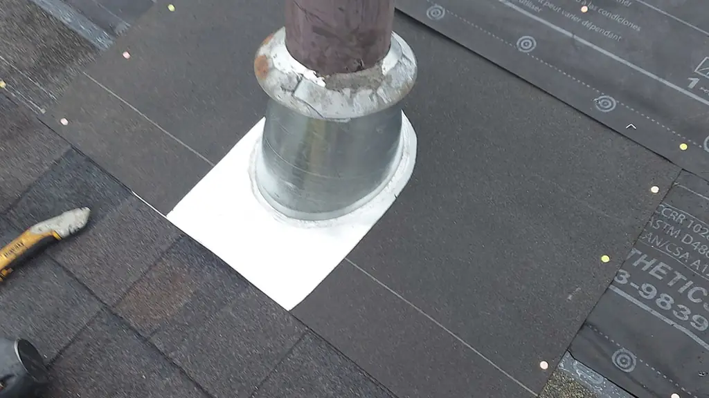 A close-up of a new galvanized plumbing vent pipe with a freshly flashed metal boot and a white membrane patch around its base. Fraser Roofing