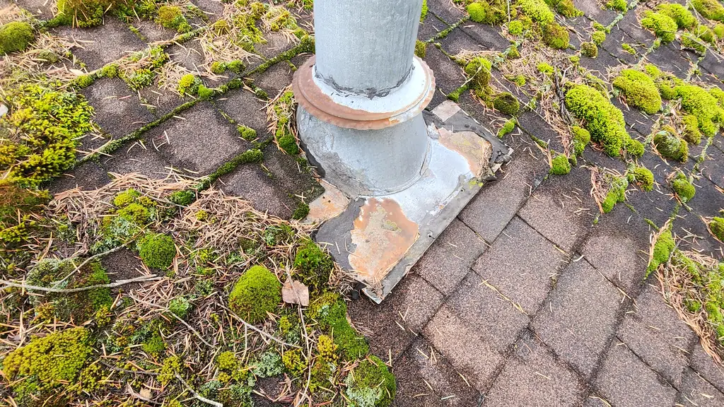 Close detail of a galvanized metal plumbing stack vent pipe with a rubber boot flashing at its base. Fraser Roofing