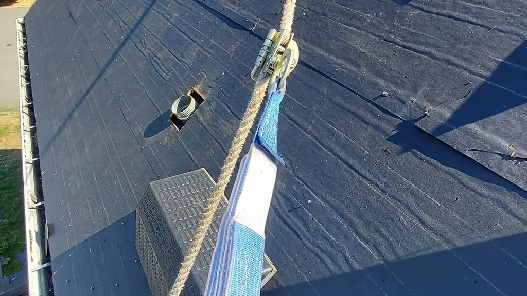 A close view down a torn-off roof slope covered mostly in black synthetic underlayment. Fraser Roofing