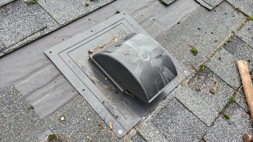 A new black plastic roof vent labeled 'Model FV-20' has been set into fresh asphalt shingles, with felt underlayment still exposed at the ridge nearby. Fraser Roofing