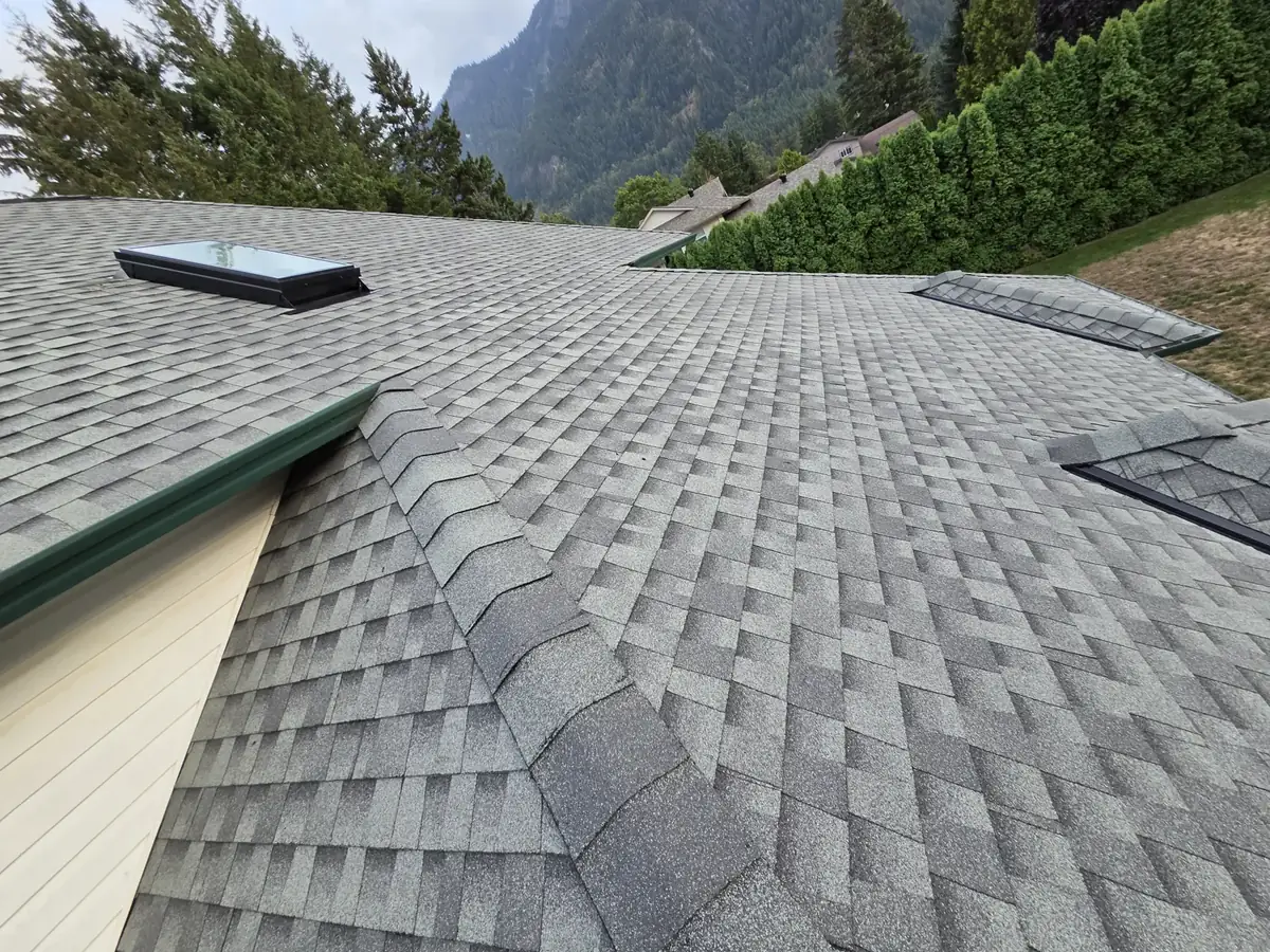 Finished shingle roof with skylights, mountain behind